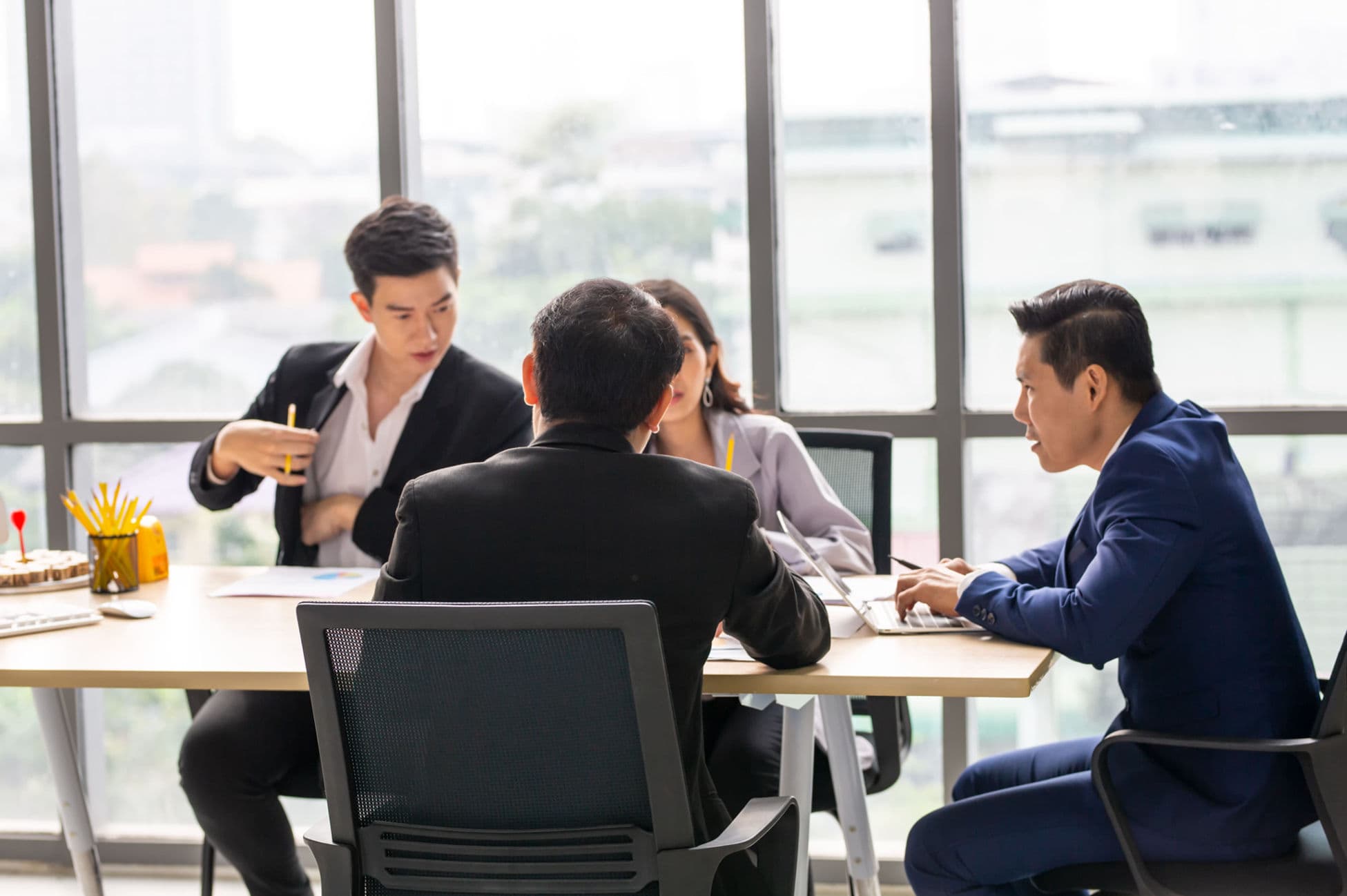 A customer support team collaborating on canned response workflows in a meeting room