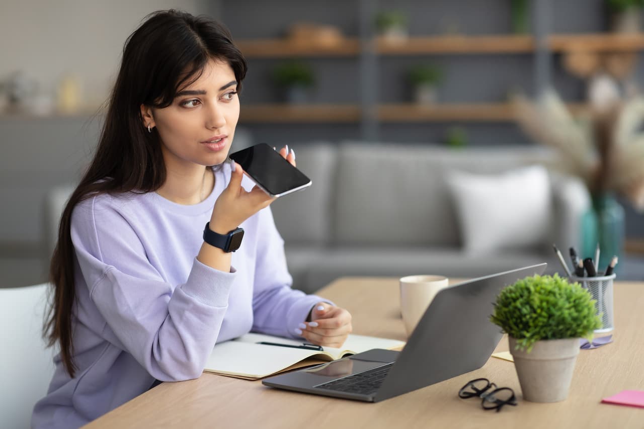 a woman talking to a voice assistant on her phone
