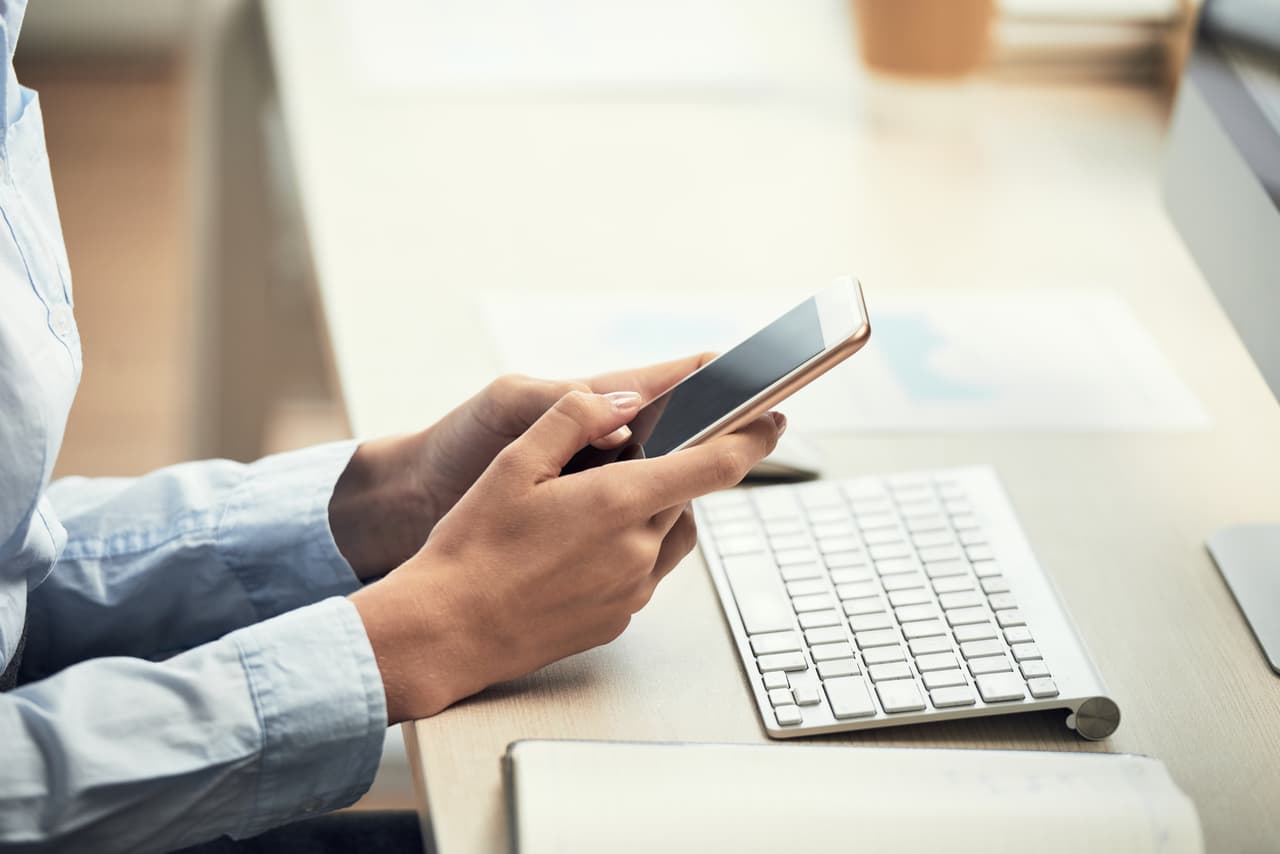 Woman texting on her phone interacting with a chatbot welcome message
