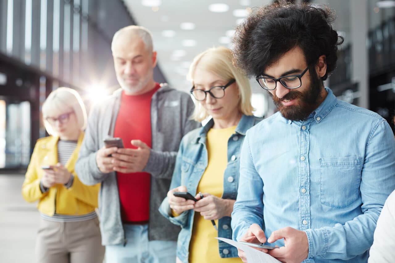 Group of people from different backgrounds texting on their phones