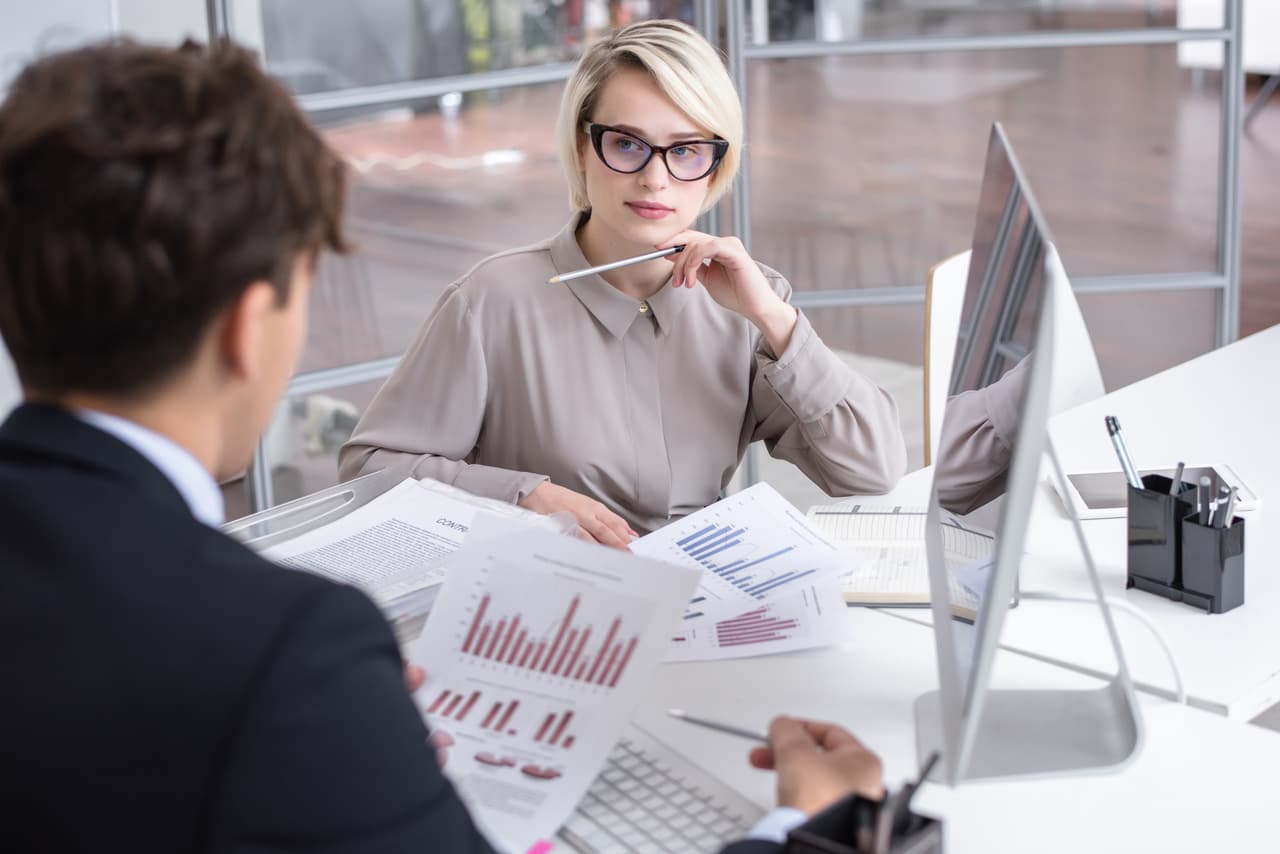 Customer support team reviewing live chat conversation analytics in a weekly performance meeting