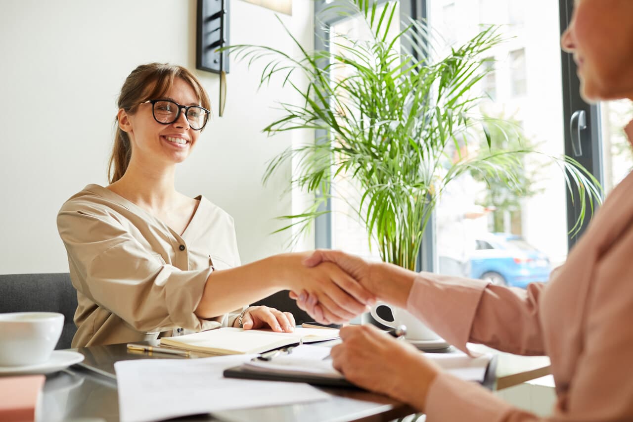 Two people shaking hands representing a successful chatbot-to-human handoff