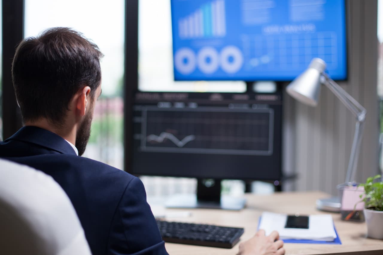 Support manager analyzing live chat performance metrics and KPI dashboards on screen