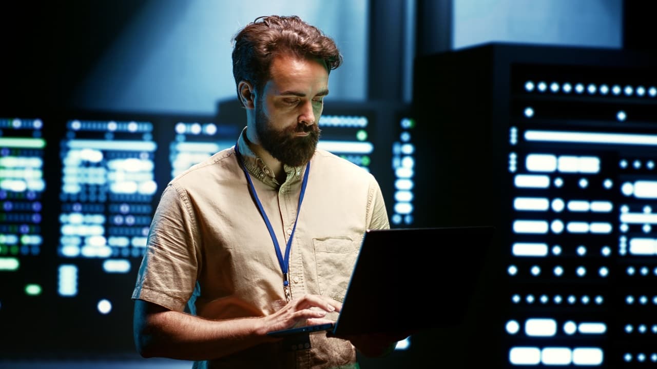 a man standing among data and checking the to reconfigure