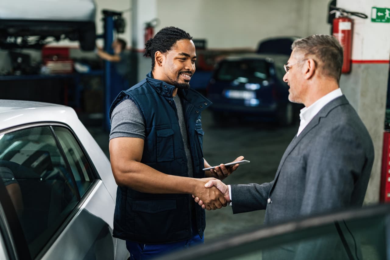 two men shaking hands for the service of fixing the car