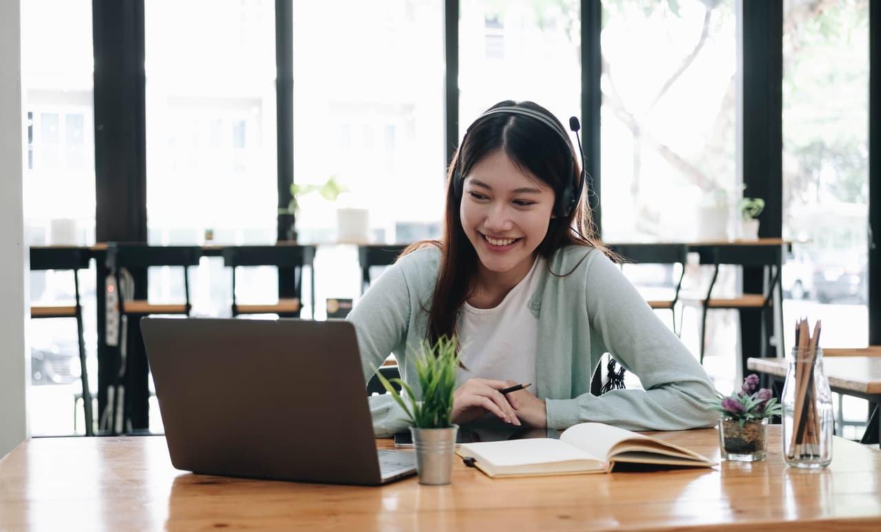 Woman wearing headphones engaged in an online learning session