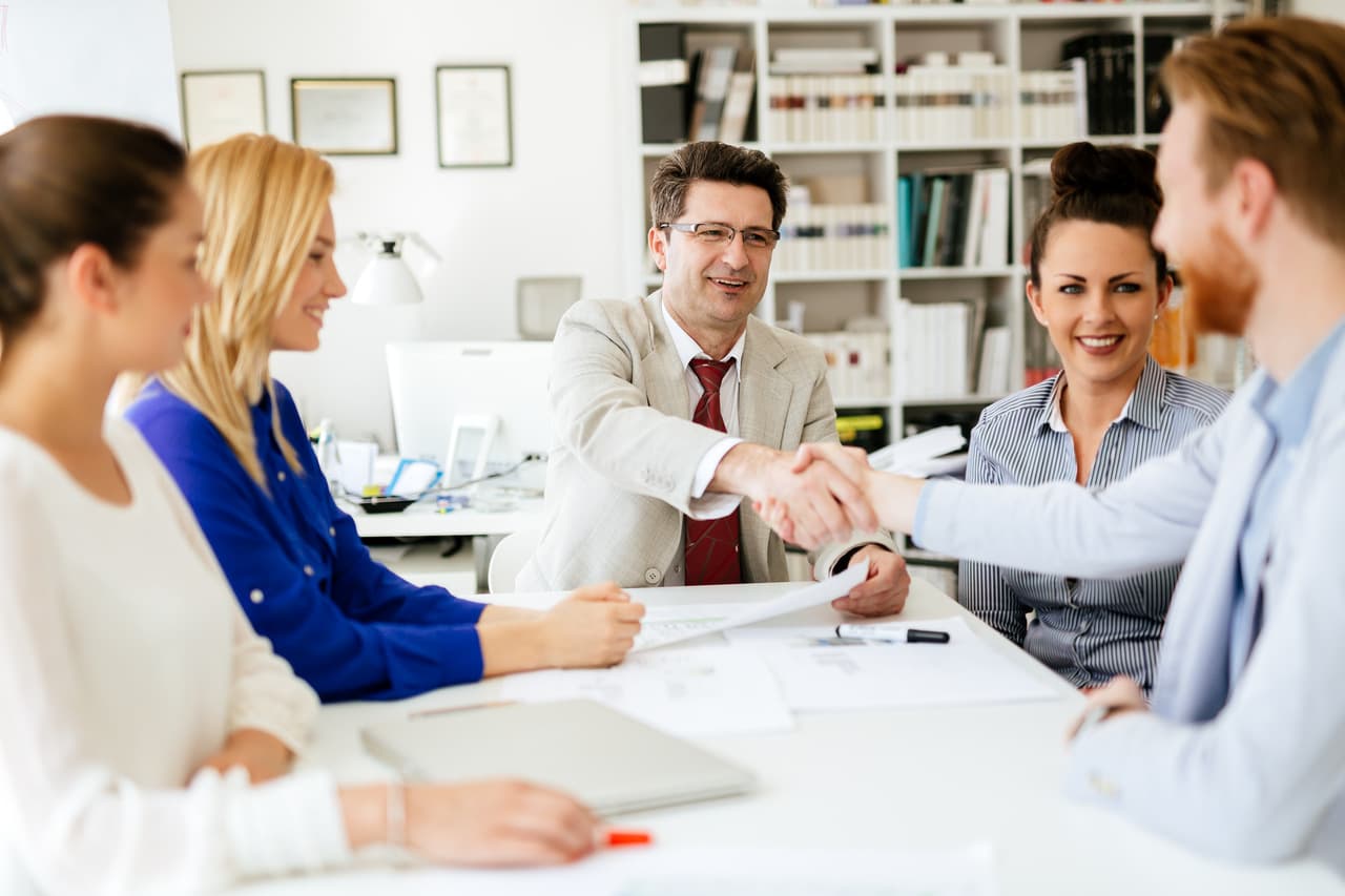 a group of people from companies making an agreement and shaking hands